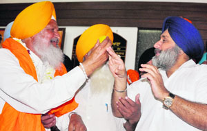 New District Planning Board chairman HS Gabria offers sweets to Sukhbir Badal in Ludhiana on Tuesday.