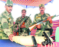 BSF men display the items recovered from the killed smuggler at Khemkaran in Tarn Taran on Tuesday