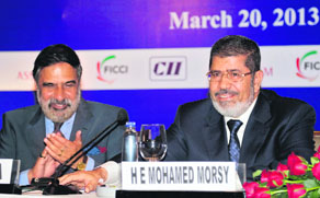 Egyptian President Mohamed Mursi (R) speaks during a business meeting as Commerce & Industry Minister Anand Sharma applauds in New Delhi on Thursday. Mursi is in India on a state visit.