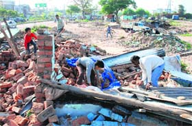 People collect their scattered goods after their houses were demolished by the HUDA authorities at Azad Colony, Sector 3, Panchkula, on Wednesday