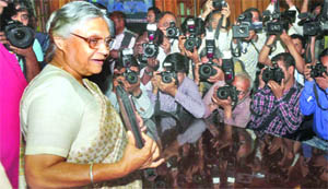 Chief Minister Sheila Dikshit shows the papers as she arrives to present the Annual Budget at Delhi Vidhan Sabha in New Delhi on Wednesday.