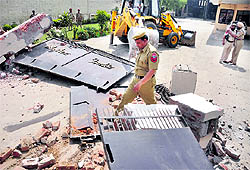 A JCB machine pulls down a gate on the main GT Road in Ludhiana on Wednesday