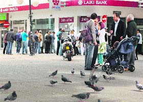 People line up outside a Laiki Bank branch to withdraw money from an ATM in Cypriot capital Nicosia on Thursday
