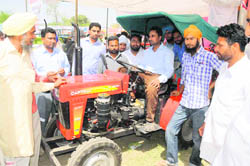 Visitors to the Kisan Mela try out a tractor on Thursday