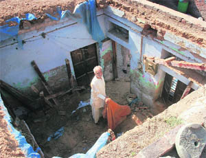 A man stands in the midst of debris after the roof of a house collapsed in Ambala on Thursday. 