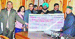 Chief Minister Virbhadra Singh being presented a cheque for Rs 1 crore by Industries and IPR Minister Mukesh Agnihotri, along with Bawa Hardeep Singh, Chairman, HP Building and Other Construction Workers Welfare Board, towards the CM Relief Fund in Shimla on Wednesday