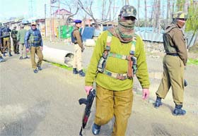 CRPF men guard the area where the BSF convoy was attacked by militants on the outskirts of Srinagar on Thursday