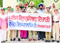 Police officers release the women helpline number at Sidhwan Bet in Jagraon on Thursday. 