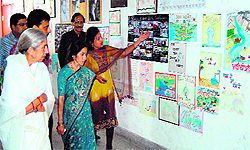 Former minister Laxmi Kanta Chawla and members of the NGOs look at a painting exhibition organised to celebrate the World Water Day in Amritsar on Friday