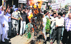 Owners of shops, located on the Jail road, burn an effigy of the SAD-BJP government in protest against the imposition of property tax in Jalandhar on Friday. Photo: Sarabjit Singh