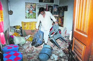 The house owner collects household items as his family had a narrow escape when the roof of the Sarwal locality residence in Jammu collapsed. 