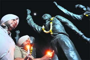 On the eve of Martyrdom Day of Shaheed Bhagat Singh, Rajguru and Sukhdev, policemen light candles in front of their statues on Jagraon Bridge in Ludhiana on Friday.