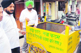 Congress councillor Gurinder Rishi (left) introduces four garbage-lifting trolleys in Amritsar on Saturday.