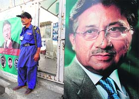 A guard at the entrance of former president Pervez Musharrafs campaign office, decorated with his posters, in Karachi