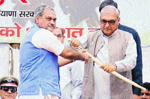 MLA Venod Sharma gives a sword to Chief Minister Bhupinder Singh Hooda on the Marytrs Day at HUDA ground in Ambala City on Saturday.