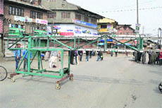 Residents block the main road in downtown Srinagar on Saturday