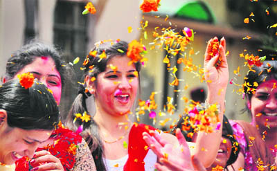 Girls enjoy at a ”Pushp Holi” at the Pinnacle Institute of Fashion Technology in Ludhiana.