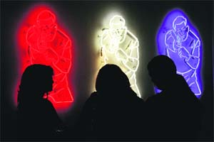 Women stand in front of "Target", a neon artwork by artist collective, Type A, during the recent press preview at the 2013 Armory Show, one of the worlds top art events featuring the most influential artworks of the 20th and 21st centuries, at Pier 92 and 94 in New York