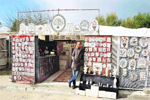 A man waits for tourists to visit his souvenir shop near the archaeological site of Carthage. It was founded in the 9th century B.C. on the Gulf of Tunis. Carthage is a popular tourist attraction