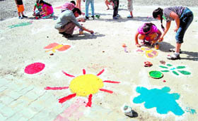 Children paint a parking lot in Amritsar on Sunday.