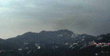 Clouds hover in the Mussoorie sky on Sunday. Slight drizzle brought the temperature down in the town. 