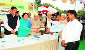 Governor Aziz Qureshi gives away the runnng trophy to the staff of IIT, Roorkee, in Dehradun on Sunday