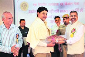 Dr PP Bhojvaid, Director, FRI, gives a memento to a participant of Yamunanagar Kisan Mela in Dehradun on Sunday