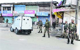 Paramilitary soldiers secure an area where militants opened fire on a police patrol in a busy market in Sopore district on Sunday