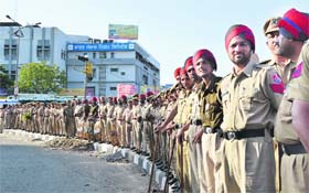 Policemen stand guard during a protest of teachers at the Grain Market in Ludhiana on Sunday