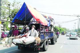 Passengers travel on a modified tractor-trailer in Ludhiana