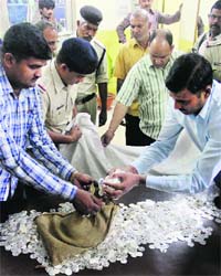 The railway police with silver coins worth Rs 60 lakh seized during a raid on a train at the Allahabad railway station on Sunday