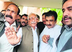 Caretaker PM Mir Hazar Khan Khoso waves as he arrives to brief mediapersons in Islamabad on Sunday
