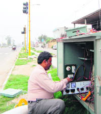 An employee of the Powercom connects the traffic light points at New Amritsar-Jalandhar bypass. 