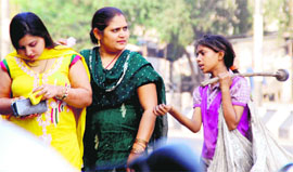 A beggar seeks alms from women in Bathinda.
