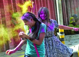 Girls play Holi in New Delhi on Monday
