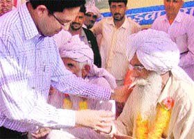 Amit Kumar Agrawal, Deputy Commissioner, Hisar, offers juice to a Jat agitator for ending his fast at Mayyar in Hisar on Monday