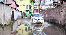 A vehicle wades through a waterlogged road in Srinagar on Monday.