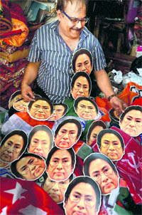 A vendor decorates his shop with masks of West Bengal CM Mamata Banerjee ahead of the upcoming Panchayat and Zila Parishad election, in Kolkata on Monday.