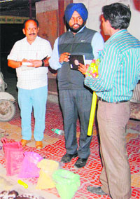Health Department officials check a shop for curbing the sale of substandard colours in Amritsar on Tuesday.