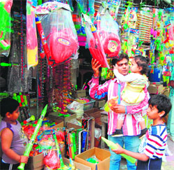 A man purchases water guns for children at a market in Amritsar on Tuesday. 