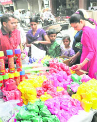  People make purchases on the eve of Holi in Dhobi Bazar on Tuesday.
