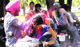 Boys forcibly apply colours on the faces of girls on the PU campus on Tuesday.