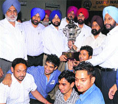 Players and staff of Lyallpur Khalsa College celebrate after clinching Teja Singh Samundari Overall Sports Trophy of Guru Nanak Dev University Amritsar for the 12th time on Tuesday.