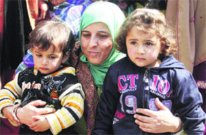 The wife of a former militant with her children participates in a protest in Srinagar on Tuesday. 