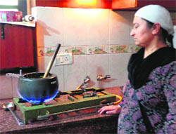 A woman cooks using biogas at her house in Bahadurpur village.