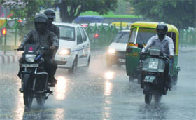 Vehicles caught in the rain in New Delhi on Thursday .