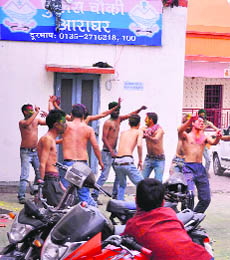 Policemen celebrate Holi at the Araghar police post in Dehradun on Thursday. 