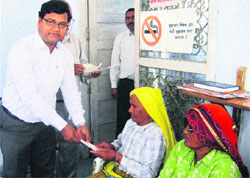 Dushiyant Kumar Behera, Deputy Commissioner-cum-Chairman of Mahendergarh Zila Sainik Board, presents annuity cheques to war widows at Narnaul. 