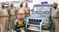 The dismissed policeman, who duped youths by promising them jobs in the Police Department, in police custody at Kartarpur in Jalandhar. Tribune photo: Malkiat Singh