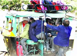 An overloaded auto-rickshaw ferries students from school to home in Jalandhar. A file photo